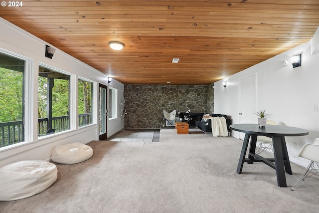 interior space featuring wooden ceiling and light colored carpet