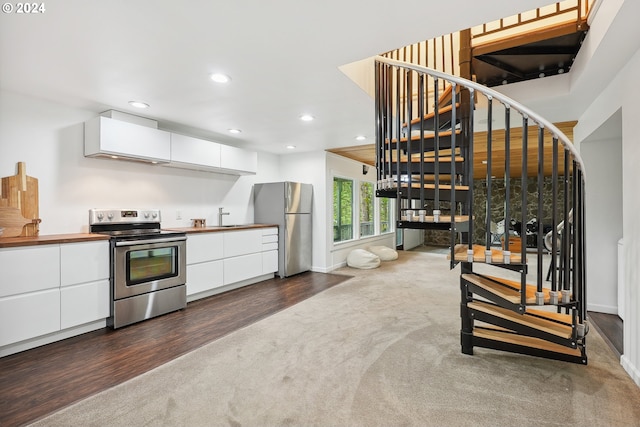 kitchen with a sink, modern cabinets, stainless steel appliances, white cabinetry, and recessed lighting