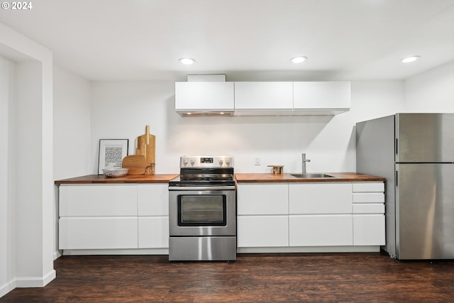 kitchen with stainless steel appliances, a sink, white cabinetry, butcher block counters, and dark wood-type flooring