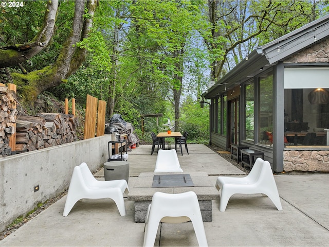 view of patio / terrace featuring outdoor dining area and a sunroom