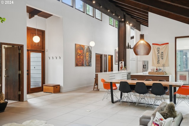 dining area with beam ceiling, high vaulted ceiling, and light tile patterned flooring