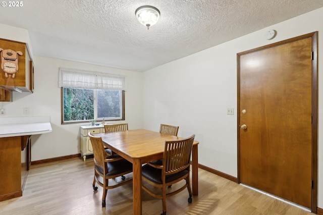 dining room featuring a textured ceiling and light hardwood / wood-style flooring