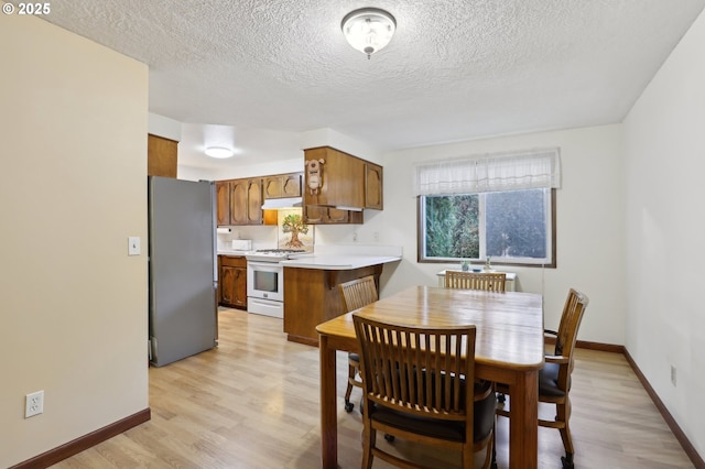 dining area featuring light hardwood / wood-style floors and a textured ceiling