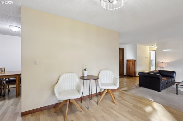 living area featuring a textured ceiling and light hardwood / wood-style floors