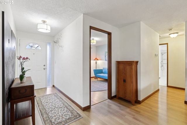 foyer featuring light hardwood / wood-style floors and a textured ceiling