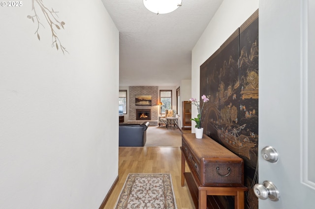 hall featuring light hardwood / wood-style floors and a textured ceiling