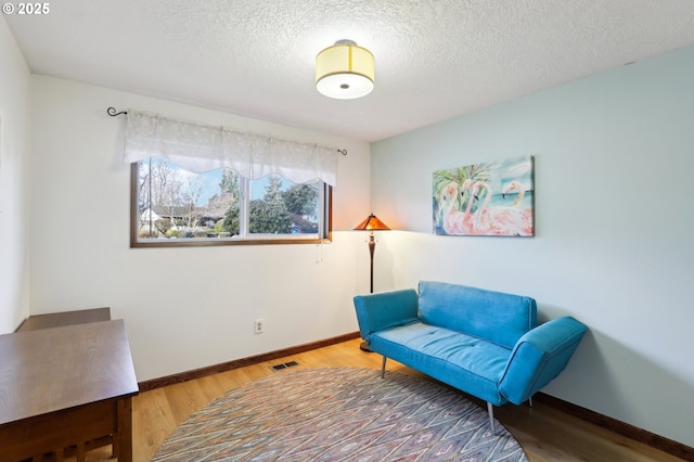 sitting room featuring wood-type flooring and a textured ceiling