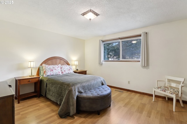 bedroom featuring a textured ceiling and light wood-type flooring