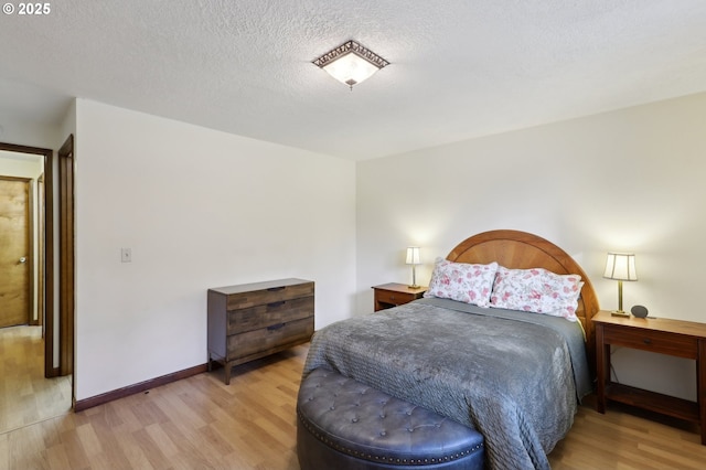 bedroom featuring light hardwood / wood-style flooring and a textured ceiling