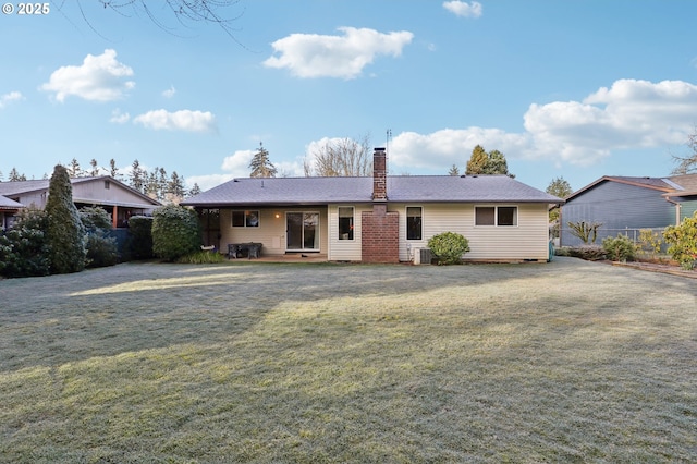 rear view of house featuring a yard