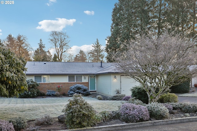 ranch-style home with a garage and a front lawn