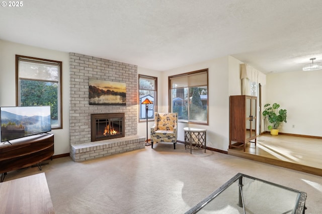 sitting room featuring a brick fireplace, a textured ceiling, and carpet flooring