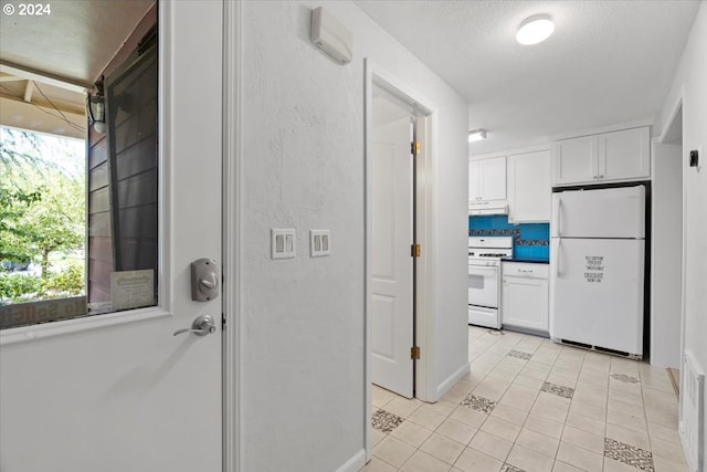 interior space with white appliances, white cabinetry, light tile patterned floors, and tasteful backsplash