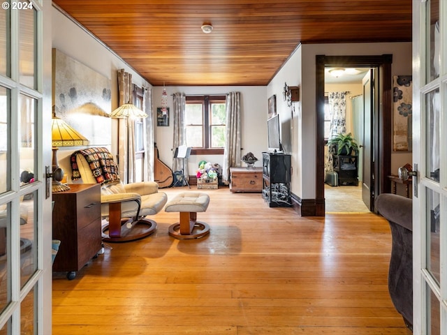 sitting room featuring french doors, light hardwood / wood-style floors, and wood ceiling