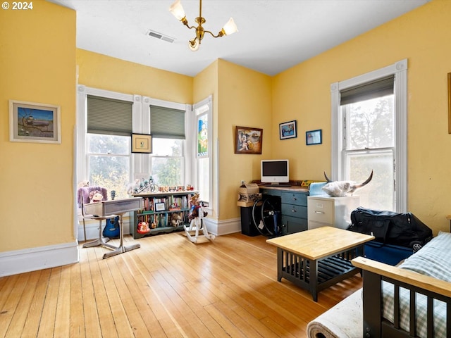 office area with plenty of natural light, light wood-type flooring, and a notable chandelier