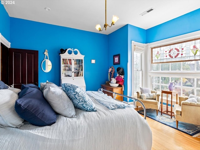 bedroom featuring hardwood / wood-style flooring and an inviting chandelier