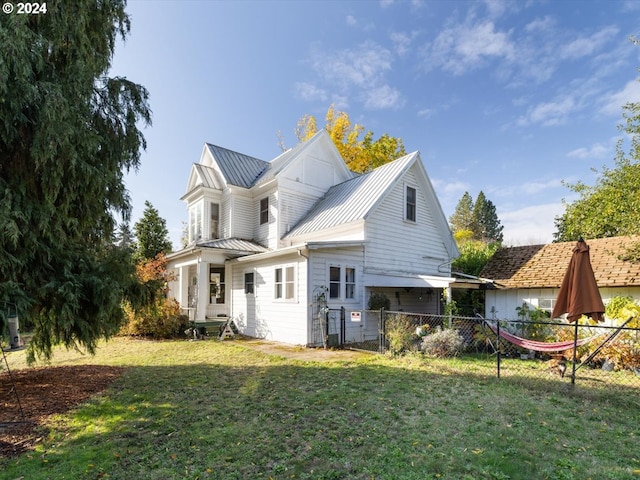 rear view of property with a lawn