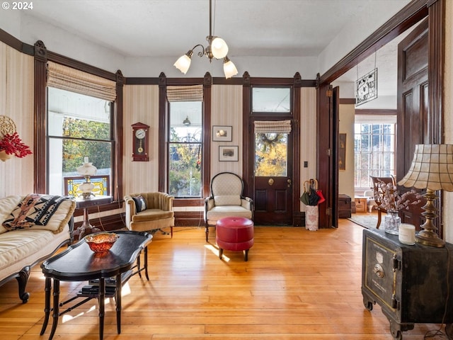 living room featuring light wood-type flooring and an inviting chandelier