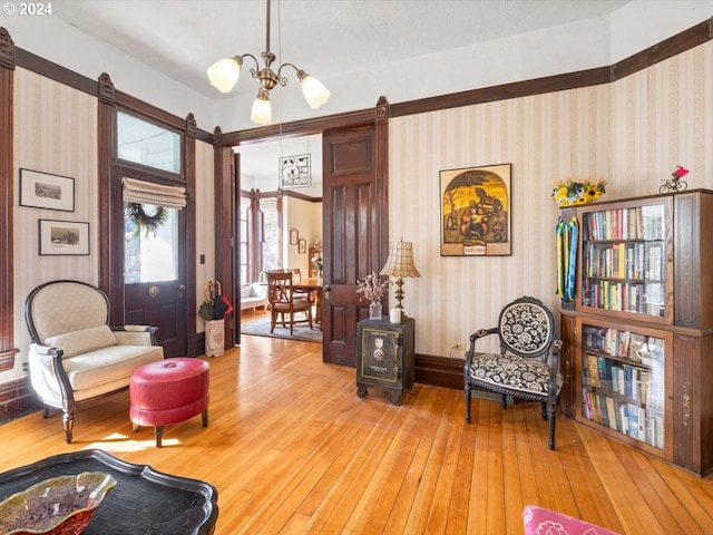 sitting room with a barn door, hardwood / wood-style floors, and a notable chandelier