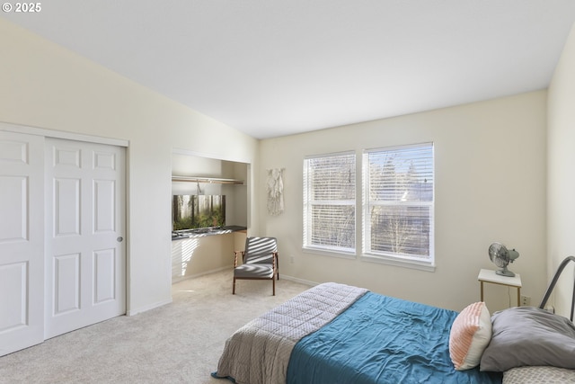 carpeted bedroom with vaulted ceiling and multiple closets