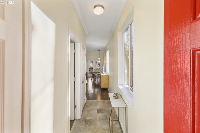 hallway featuring a notable chandelier and ornamental molding