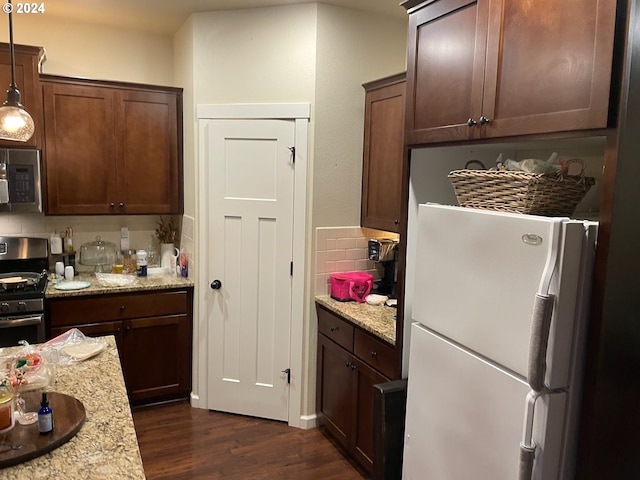 kitchen with light stone countertops, stainless steel appliances, decorative light fixtures, and dark hardwood / wood-style flooring