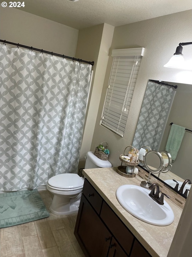 bathroom featuring curtained shower, vanity, a textured ceiling, toilet, and hardwood / wood-style floors