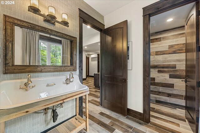 bathroom featuring wood-type flooring and a bath