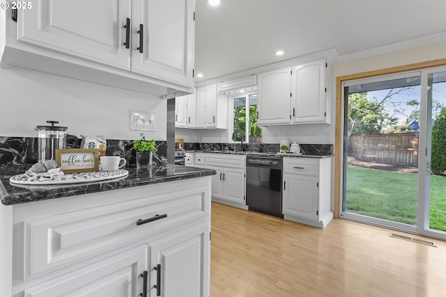 18685 SW Hennig Ct, Beaverton, OR 97003 - kitchen with black dishwasher, ornamental molding, white cabinets, plenty of natural light, and light wood finished floors