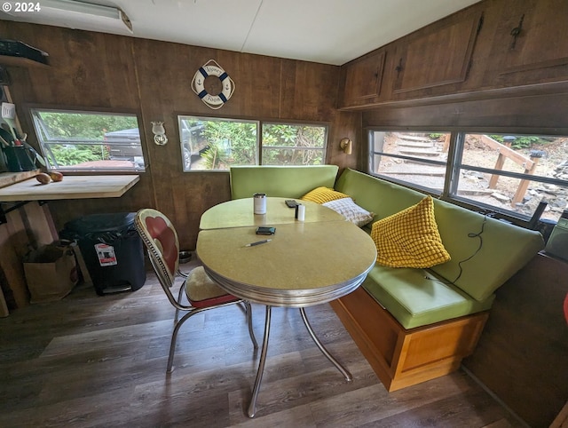 dining area featuring dark hardwood / wood-style floors and wooden walls