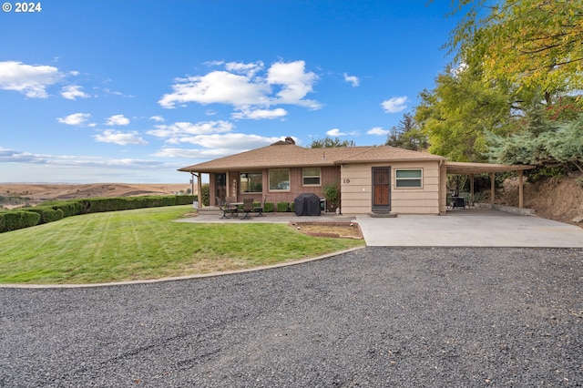 ranch-style home featuring a carport, a front yard, and a mountain view