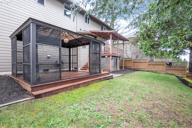 exterior space with a sunroom, fence, and a wooden deck