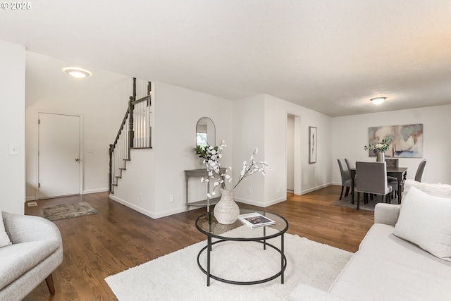 living area with stairs, wood finished floors, and baseboards