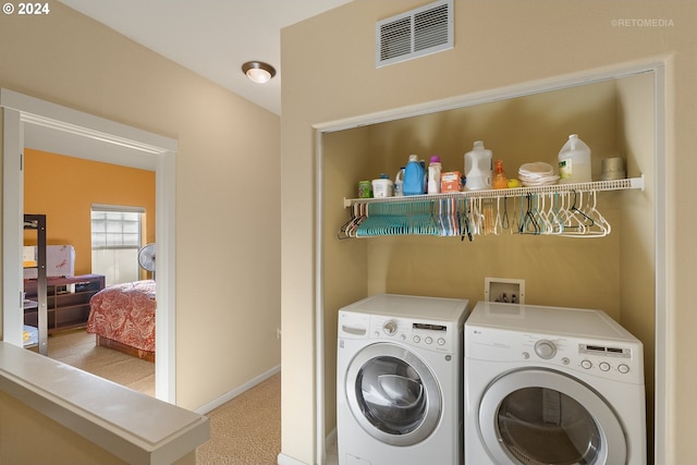 laundry area featuring light colored carpet and separate washer and dryer