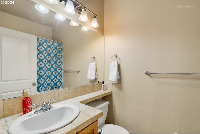 bathroom with tasteful backsplash, vanity, and toilet