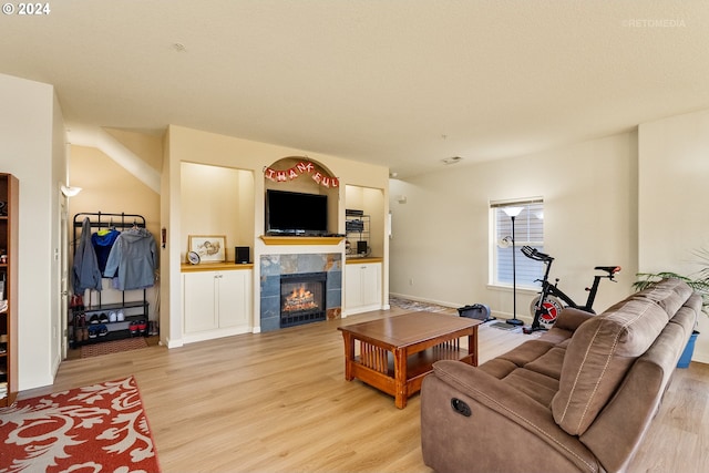 living room with a fireplace and light wood-type flooring