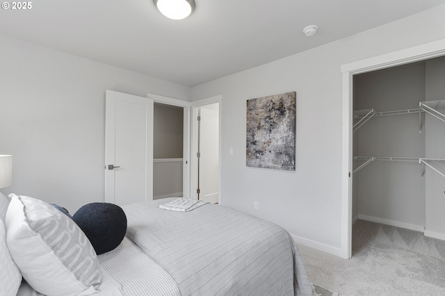 bedroom featuring a walk in closet, a closet, and carpet