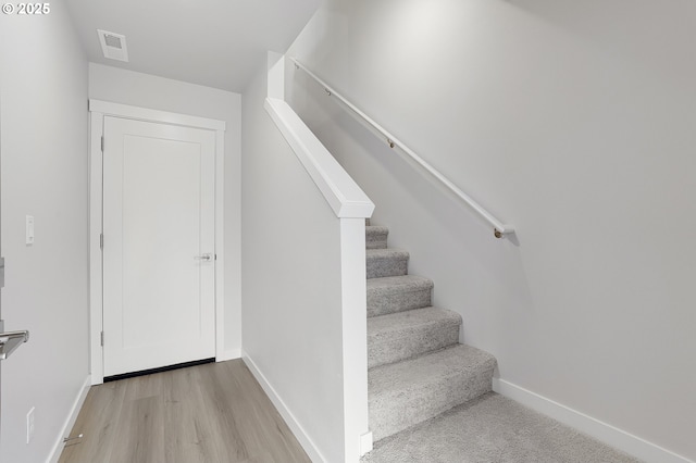 stairs with hardwood / wood-style floors