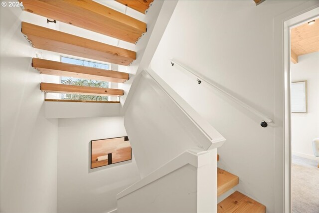 stairs featuring beamed ceiling