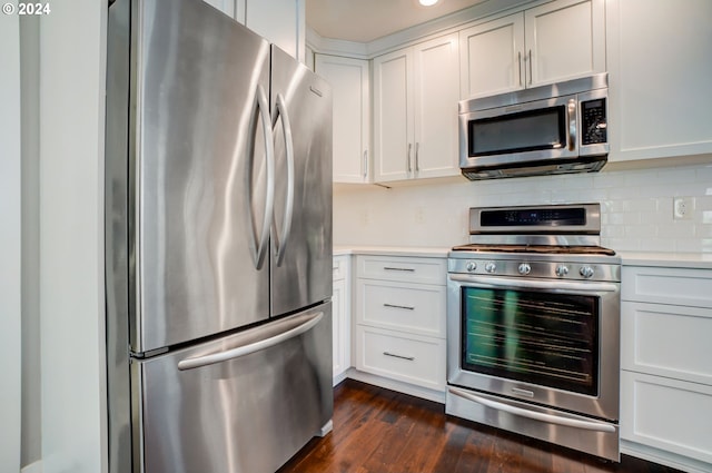 kitchen featuring stainless steel appliances, white cabinetry, and dark wood-type flooring