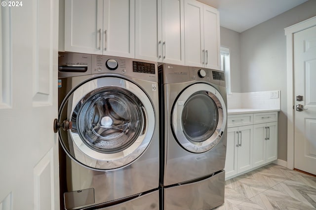 clothes washing area with cabinets and independent washer and dryer