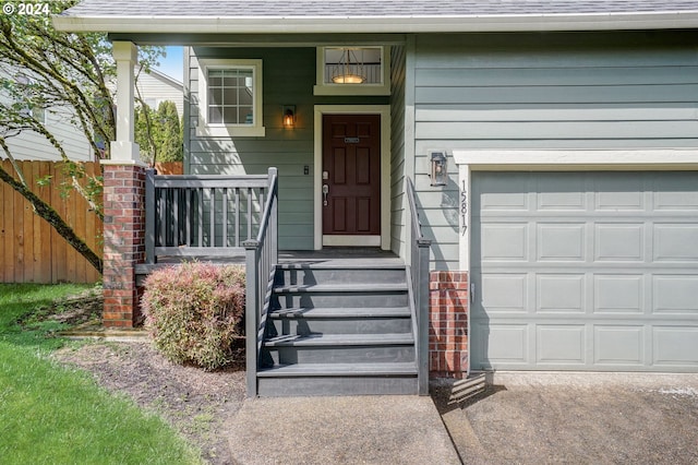 doorway to property with covered porch and a garage