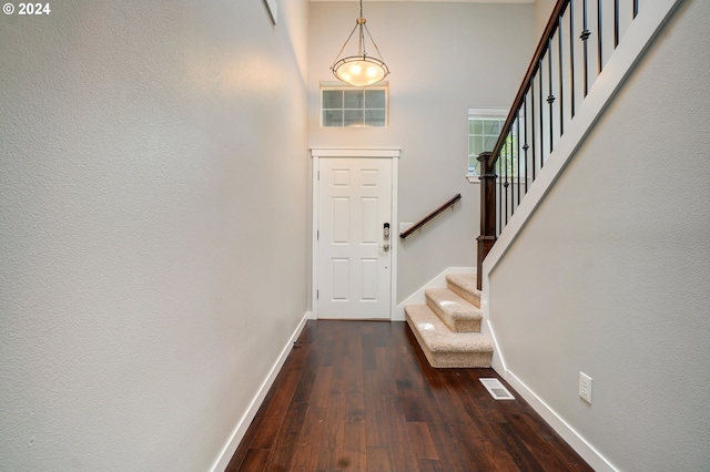 entrance foyer with dark hardwood / wood-style flooring and an inviting chandelier