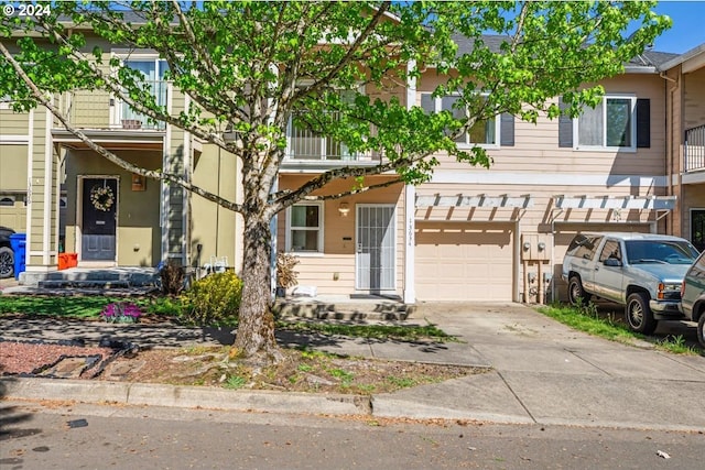 townhome / multi-family property featuring a balcony and a garage