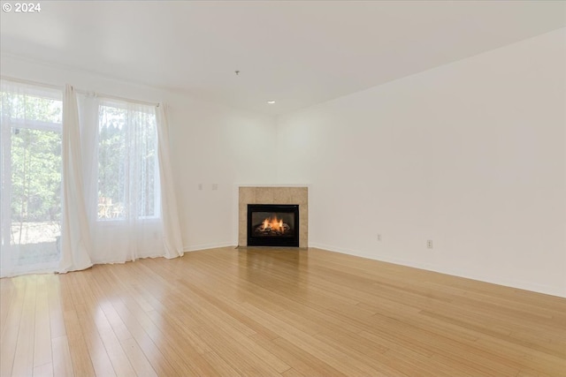 unfurnished living room featuring sink, light hardwood / wood-style floors, and an inviting chandelier