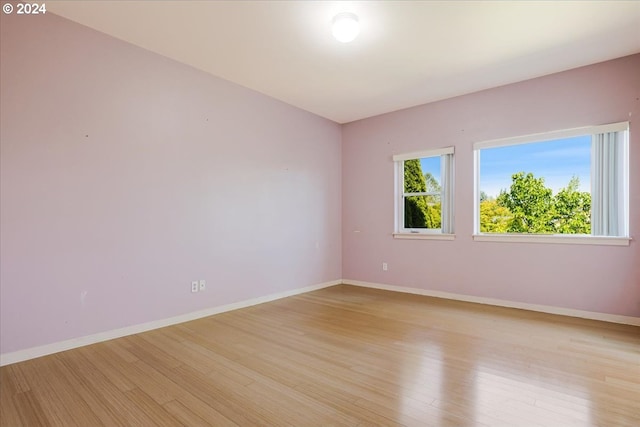 unfurnished bedroom with light hardwood / wood-style flooring and ensuite bath