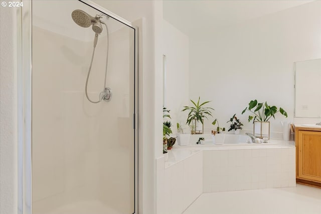 bathroom with vanity and tiled tub