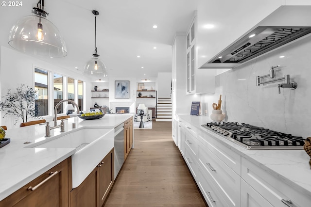 kitchen featuring dark hardwood / wood-style flooring, decorative light fixtures, sink, white cabinets, and appliances with stainless steel finishes