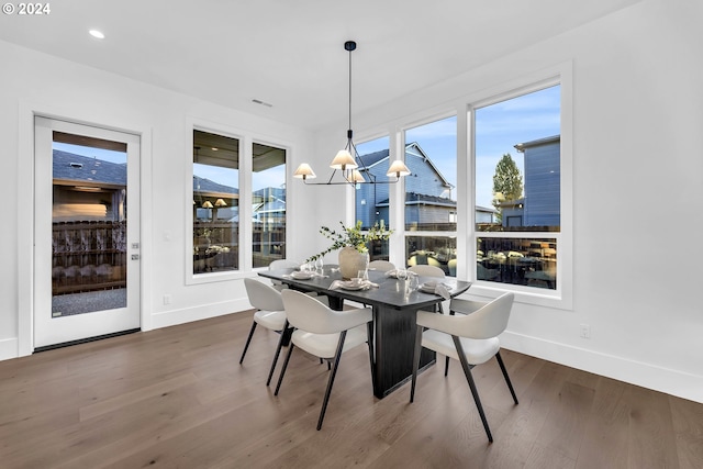 dining room with plenty of natural light, dark hardwood / wood-style flooring, and a chandelier