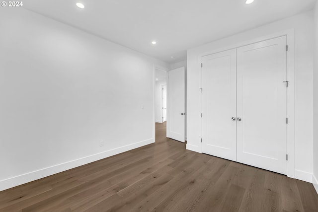 unfurnished bedroom with dark wood-type flooring and a closet